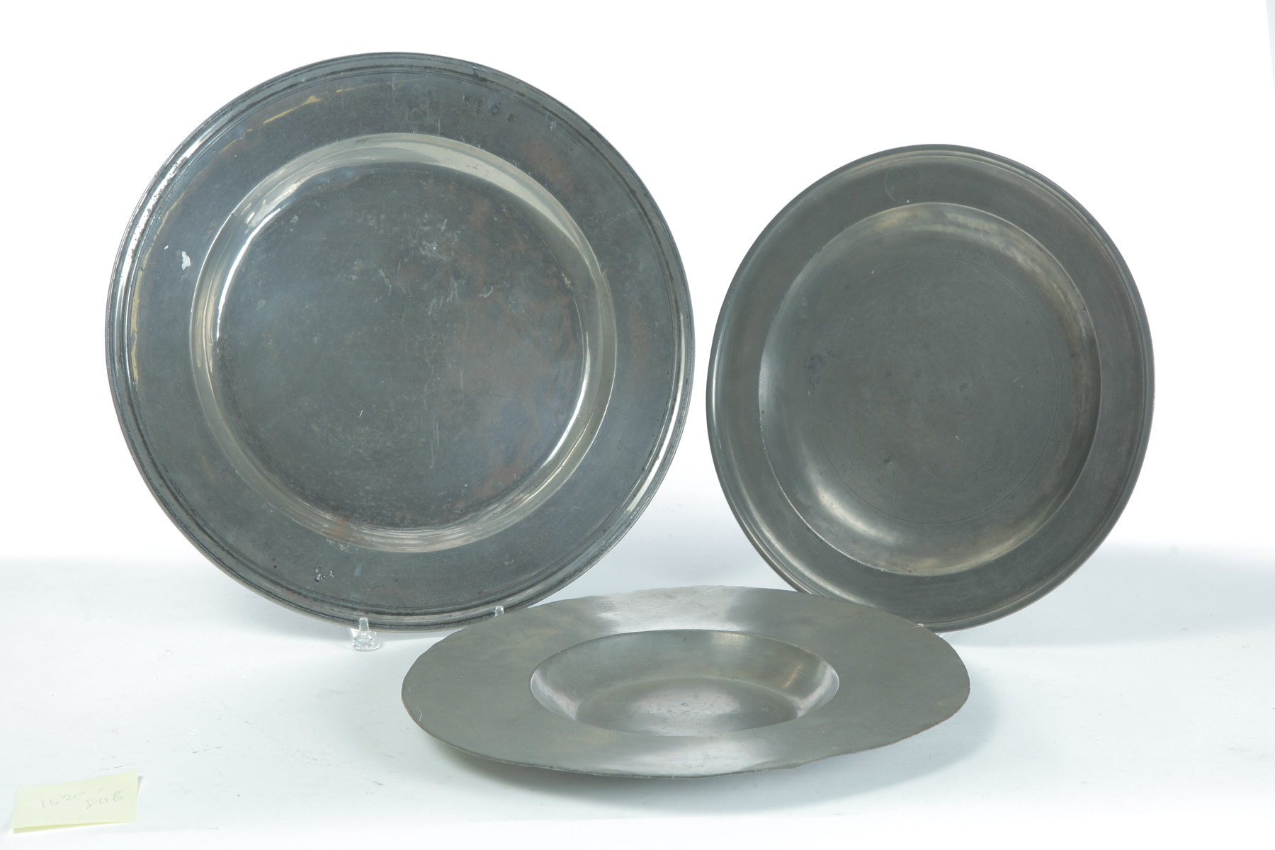 Appraisal: THREE ENGLISH PEWTER CHARGERS Eighteenth- th century Hammered booges Largest