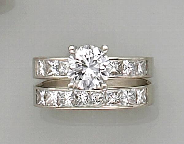 Appraisal: centering a round brilliant-cut diamond flanked by channel-set princess-cut diamonds