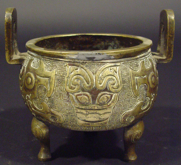 Appraisal: Oriental two handled bronze bowl cast in relief with masks