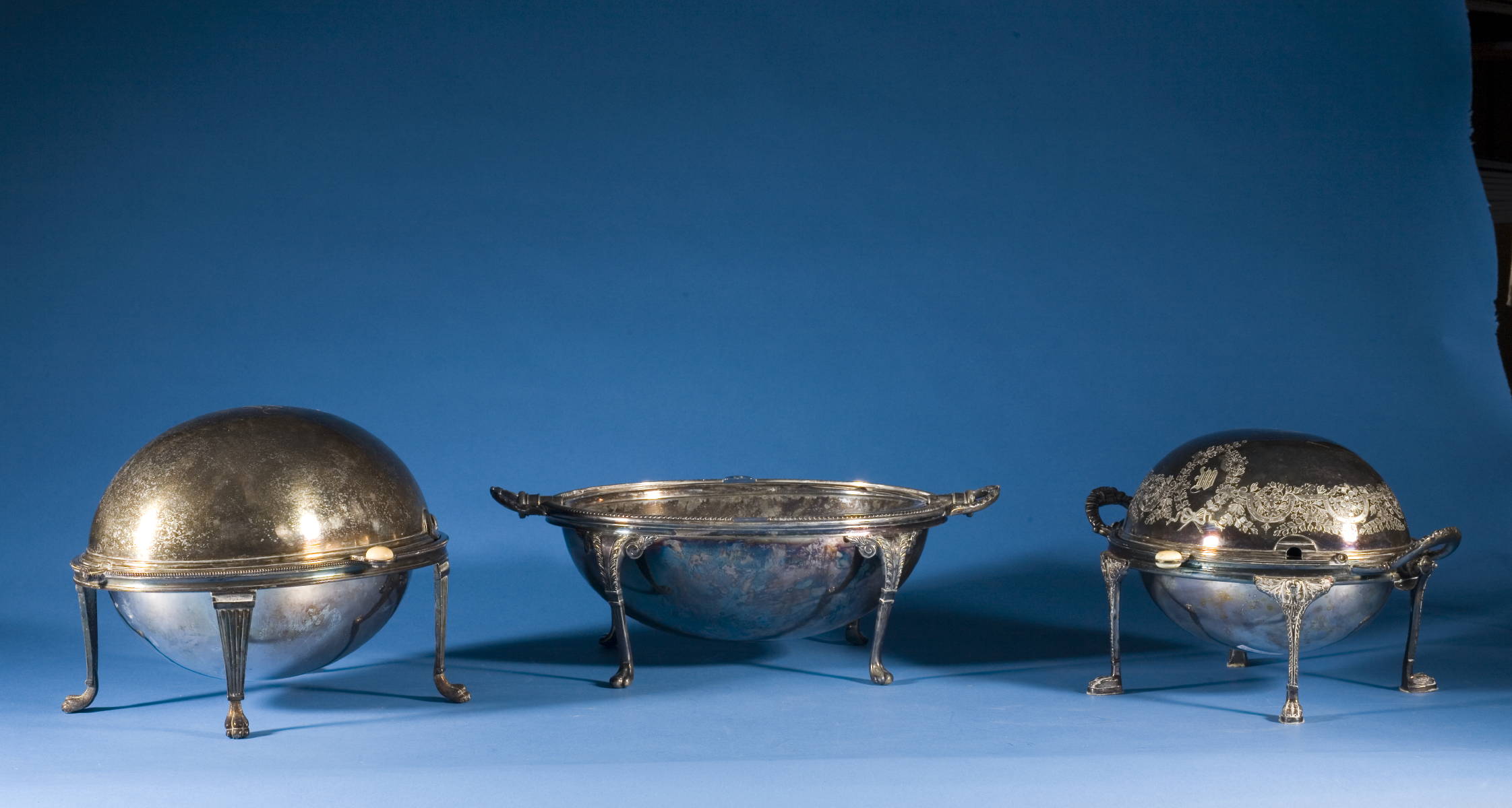 Appraisal: THREE ENGLISH SILVERPLATE BUN WARMERS WITH REVOLVING TOPS Length of