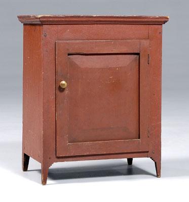 Appraisal: American red-painted tabletop cabinet paneled door and shelved interior probably