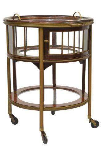 Appraisal: French round glass-top bar cart th c mahogany finish case