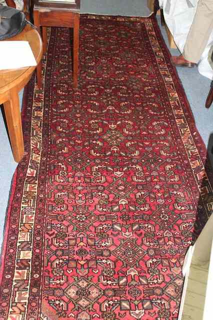 Appraisal: A WINE GROUND HAMADAN RUNNER with stylised design within a