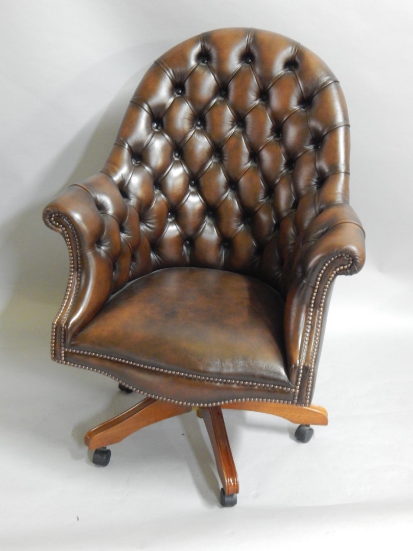 Appraisal: A reproduction office chair upholstered in brown leatherette with brass