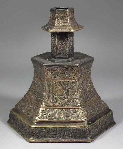 Appraisal: An Indian or Egyptian brass hexagonal candlestick inlaid with silver