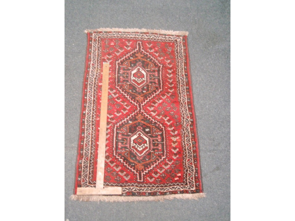 Appraisal: A Turkish design rug with two medallions on a red