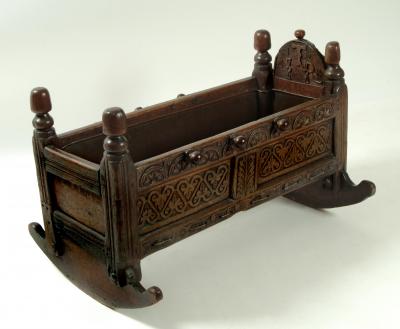 Appraisal: A CHARLES II OAK CRADLE with turned finials on reeded