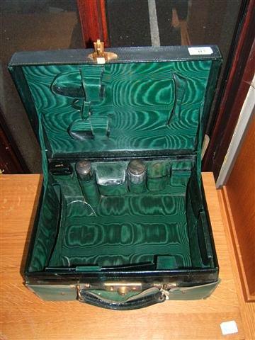 Appraisal: An early th Century green leather travelling case the fitted