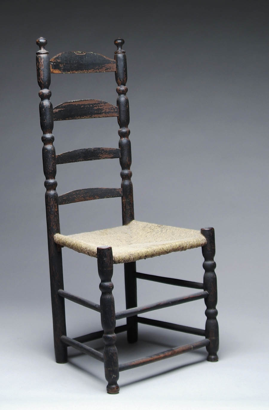 Appraisal: EARLY FOUR SLAT LADDER-BACK SIDE CHAIR IN OLD BLACK Sausage