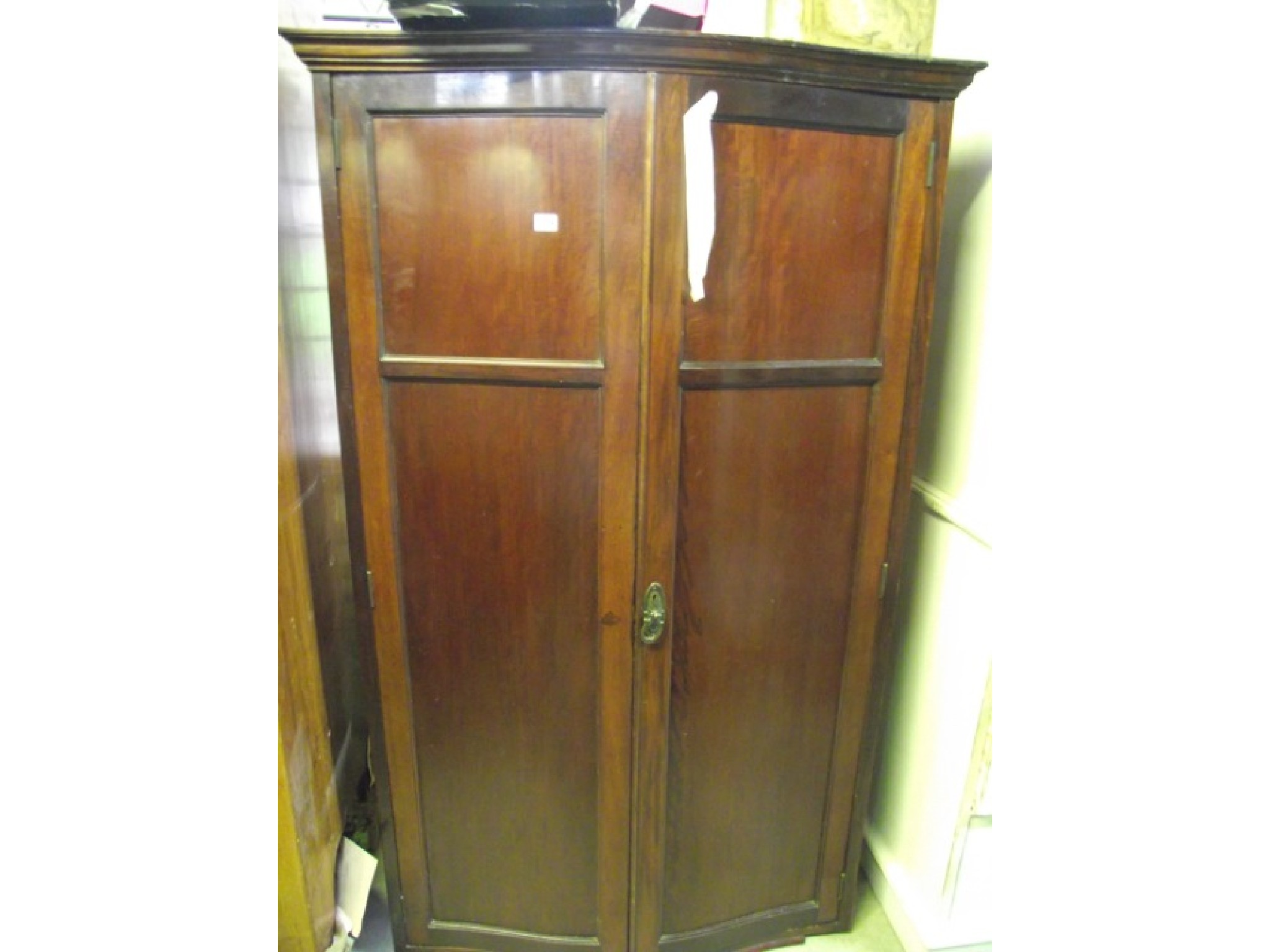 Appraisal: An Edwardian mahogany wardrobe with serpentine front enclosed by a