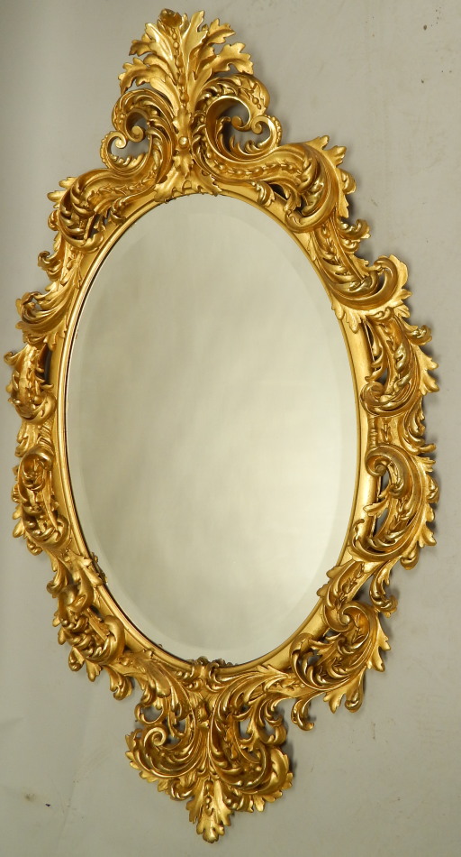 Appraisal: A large Continental giltwood and gesso oval wall mirror the