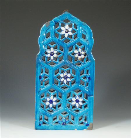 Appraisal: An Islamic turquoise glazed tile of reticulated arch form decorated