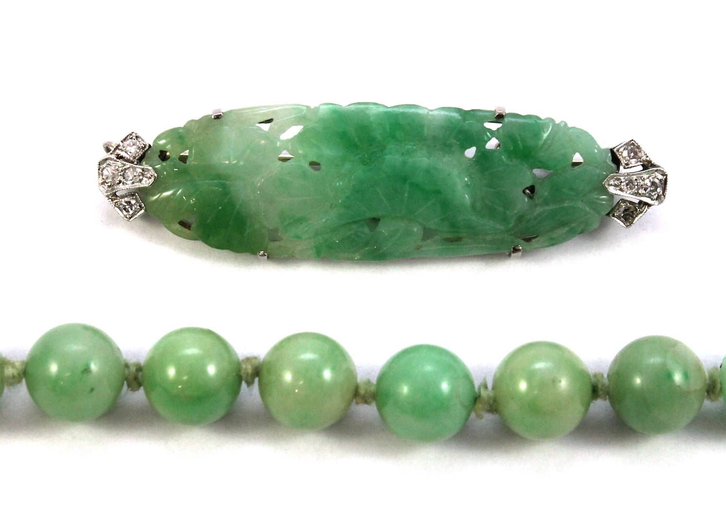 Appraisal: A carved jade and diamond set brooch in an oval