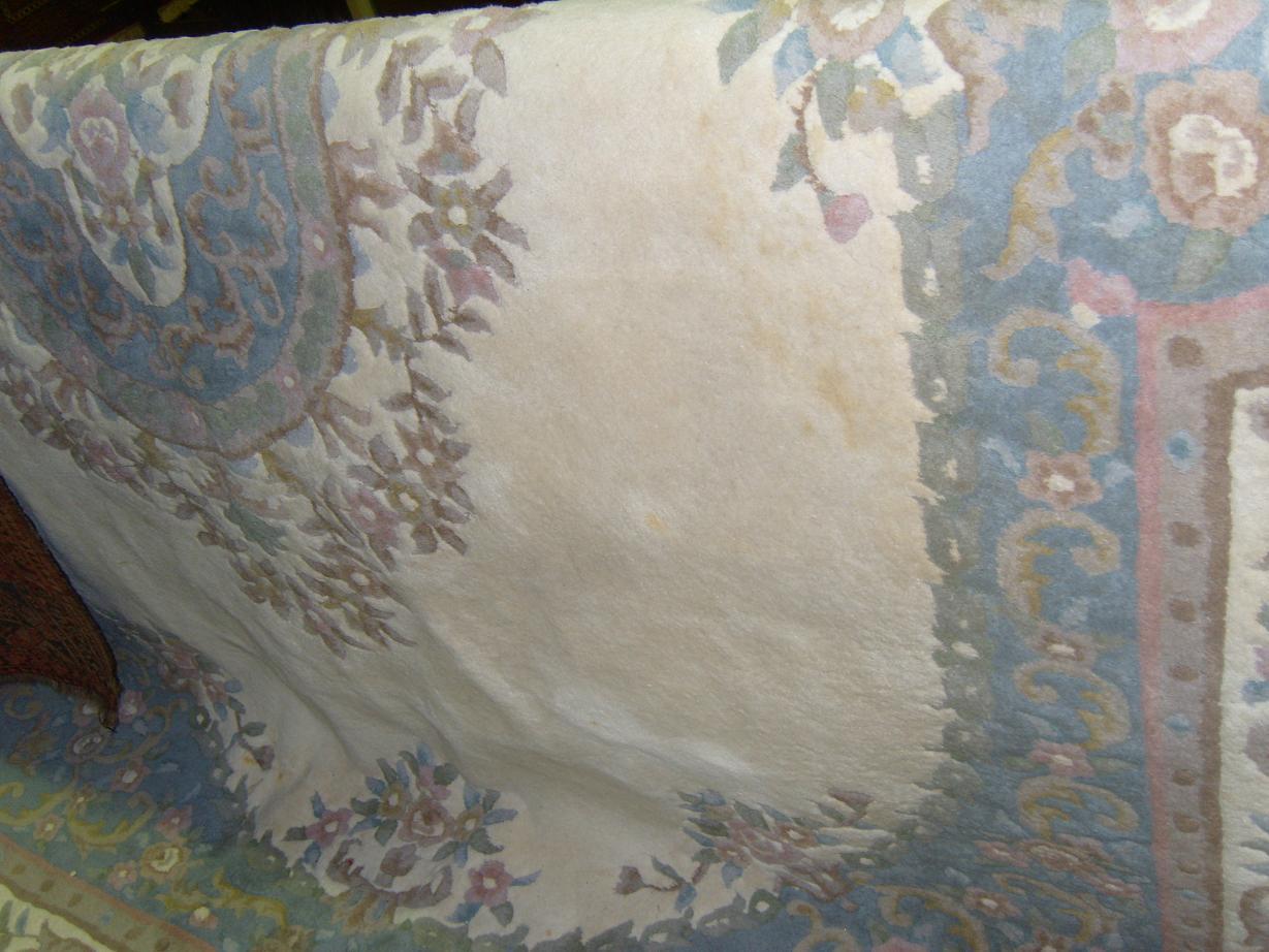 Appraisal: A large cream ground Chinese wool carpet with central floral