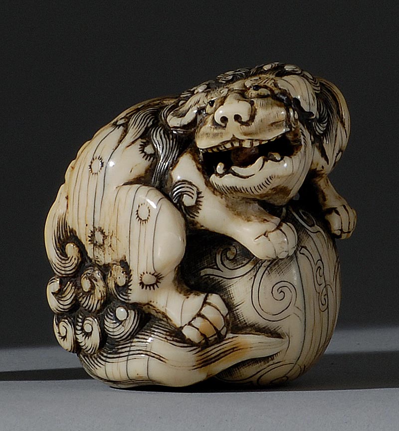 Appraisal: IVORY NETSUKE th CenturyIn the form of a lion guarding