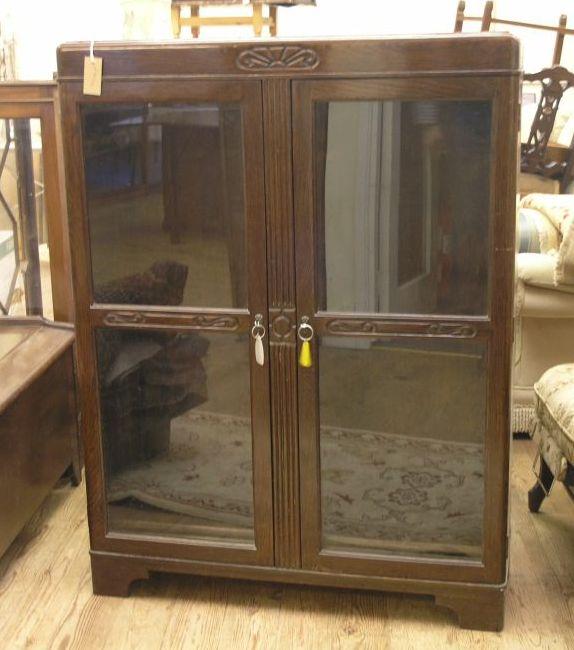 Appraisal: A dark oak bookcase enclosed by a pair of glazed