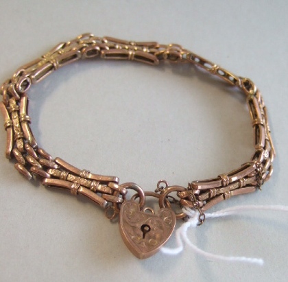 Appraisal: A gold decorated bar and oval link gate bracelet on