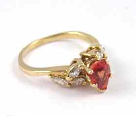 Appraisal: ORANGE SAPPHIRE AND DIAMOND RING k yellow gold with three