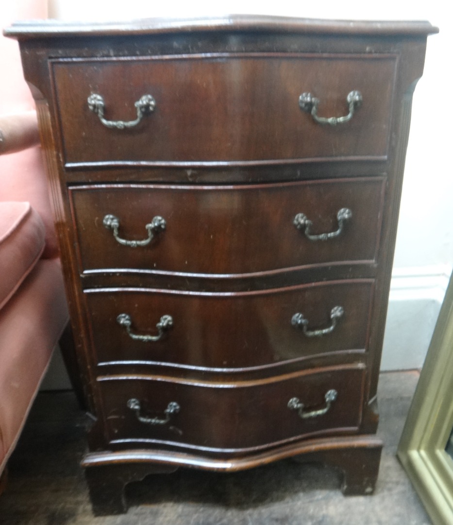 Appraisal: A small reproduction mahogany serpentine fronted chest of four drawers