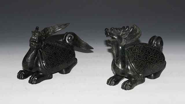 Appraisal: A PAIR OF CHINESE DARK GREEN HARDSTONE DRAGONS with pierced