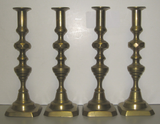 Appraisal: FOUR ANTIQUE ENGLISH BRASS CANDLESTICKS Each knobbed stem topped with