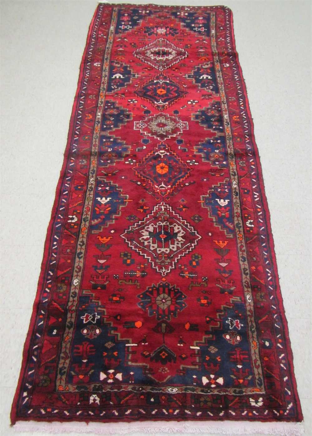 Appraisal: PERSIAN TRIBAL HALL RUG geometric medallion and half-medallion design along