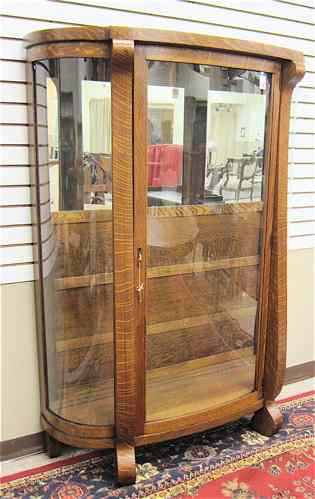 Appraisal: AN OAK AND CURVED GLASS CHINA DISPLAY CABINET Empire Revival