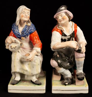 Appraisal: A pair of earthenware figures of a seated cobbler and