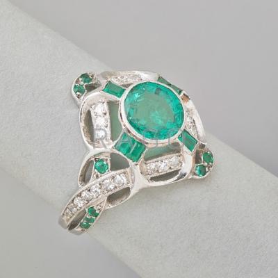 Appraisal: EMERALD AND DIAMOND PLATINUM RING Bright circular faceted emerald weighing