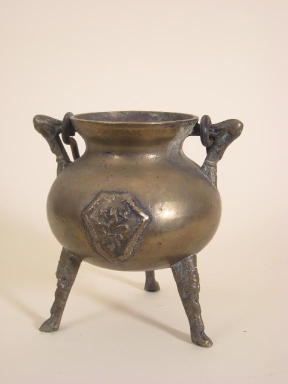 Appraisal: An early bronze Cauldron with swing handle raised cartouche on