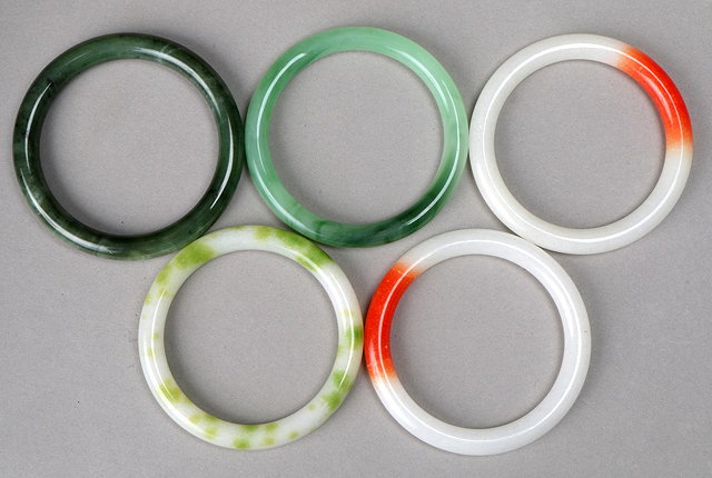 Appraisal: TWO WHITE AND ORANGE COLOURED JADE BRACELETS and three green