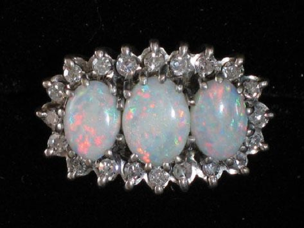 Appraisal: A DIAMOND AND OPAL CLUSTER RING the three oval graduated