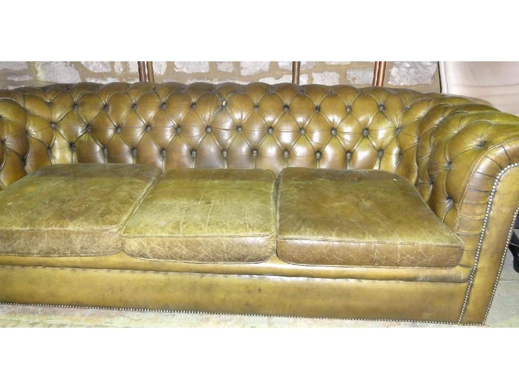 Appraisal: A green leather upholstered three seat Chesterfield sofa with button