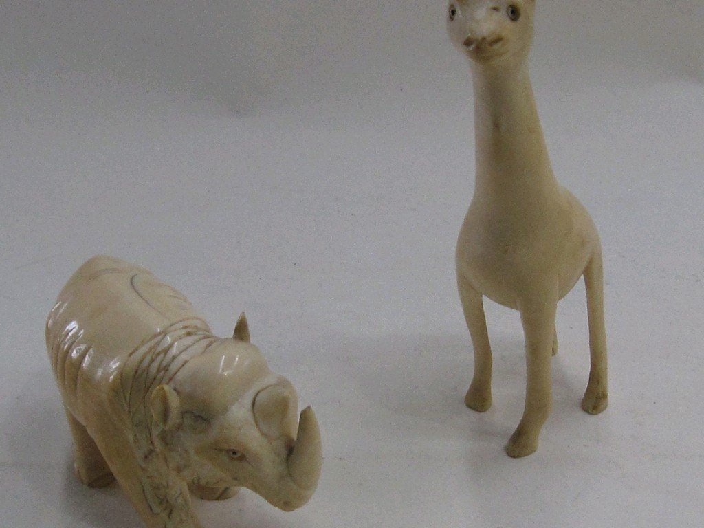 Appraisal: Lot comprising two carved ivory animals - giraffe and rhinoceros