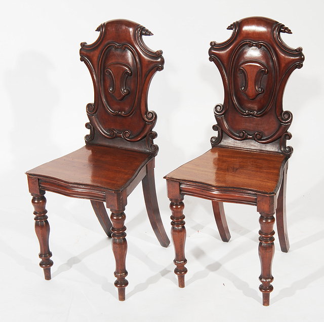 Appraisal: A PAIR OF VICTORIAN MAHOGANY HALL CHAIRS with shield shaped