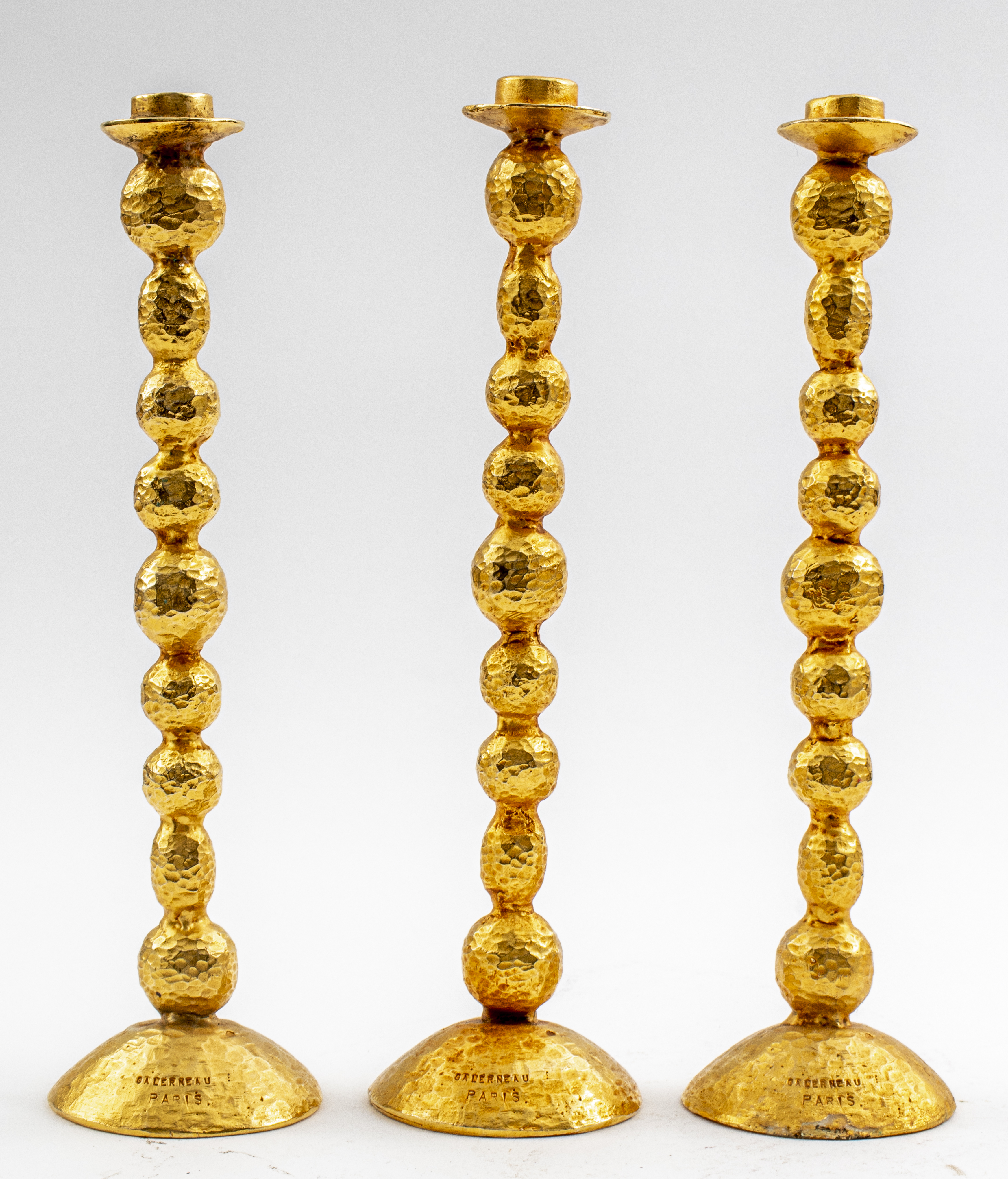 Appraisal: STEPHANE GALERNEAU PARIS CANDLESTICKS Three Stephane Galerneau Paris candlesticks gilt