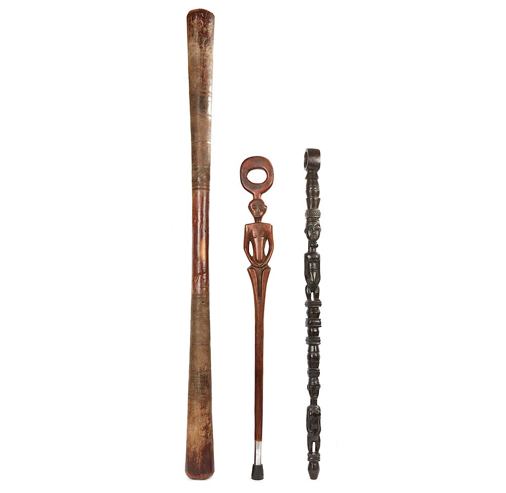 Appraisal: Two African Staffs and Large Pestle Two wooden walking staffs