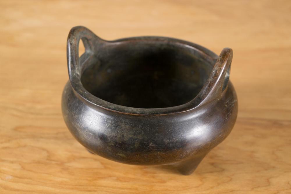 Appraisal: CHINESE BRONZE CENSER tri-footed patinated bronze with upward handles and