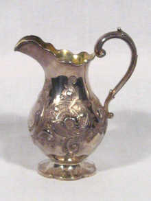 Appraisal: A silver cream jug decorated with foliage hallmarked cm high