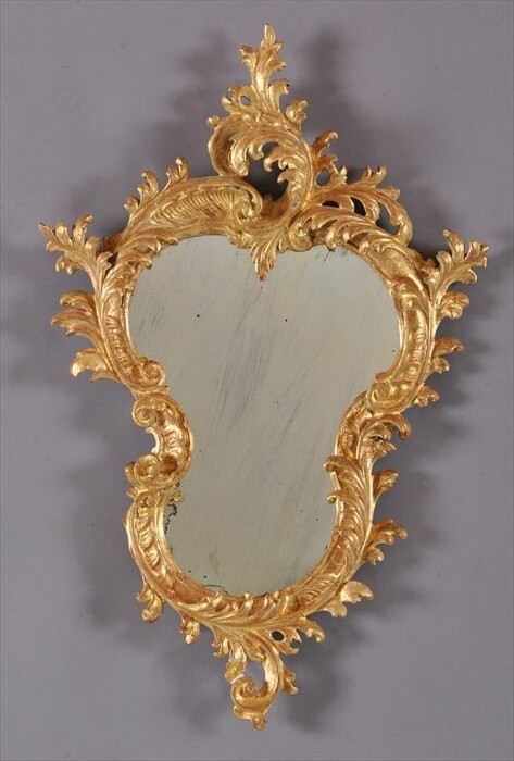 Appraisal: ITALIAN ROCOCO CARVED GILTWOOD SMALL MIRROR The cartouche-shape plate within