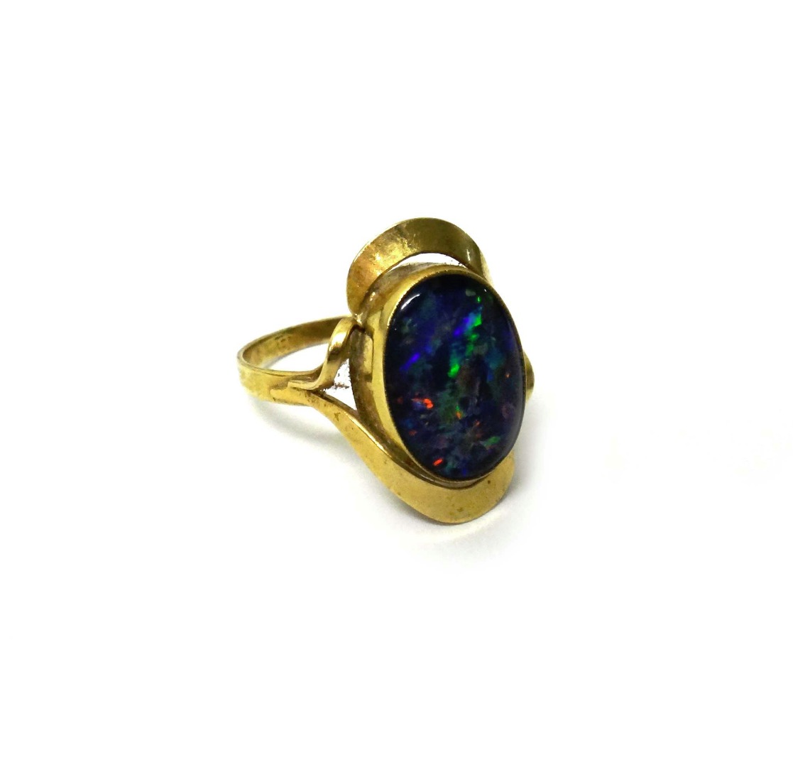 Appraisal: A gold ring mounted with an oval opal doublet between