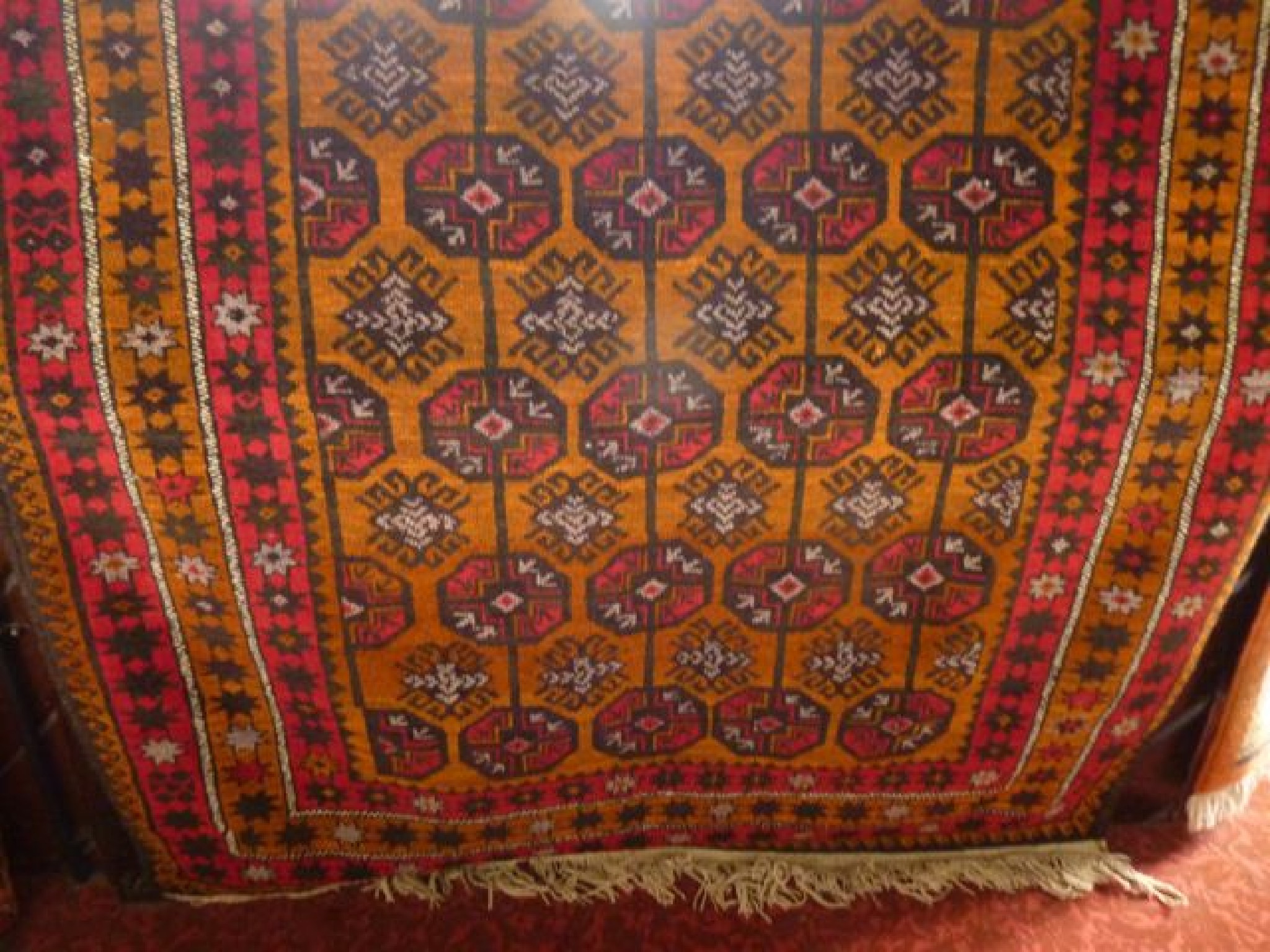 Appraisal: A Persian style wool rug with amber ground field multi-medallion