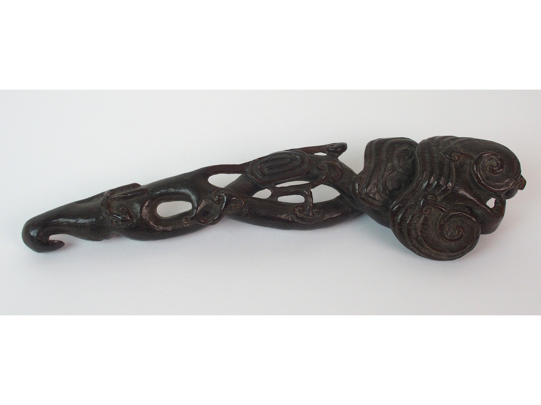 Appraisal: A Chinese carved horn ruji sceptrepierced and carved with scrolling