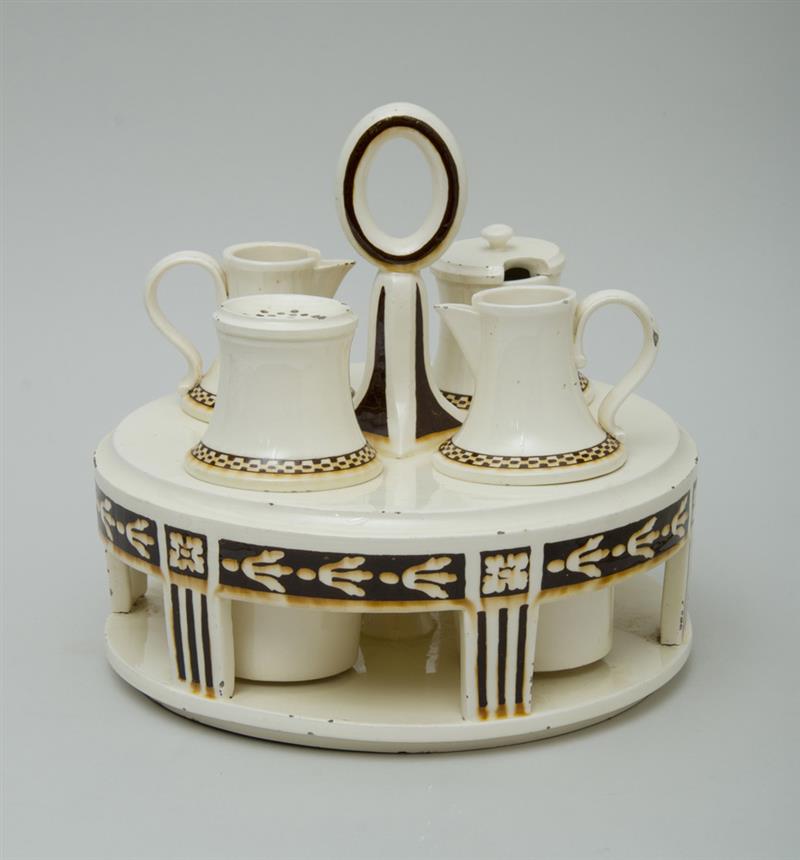 Appraisal: CONTINENTAL IVORY-GLAZED POTTERY CONDIMENT STAND The exterior painted with brown