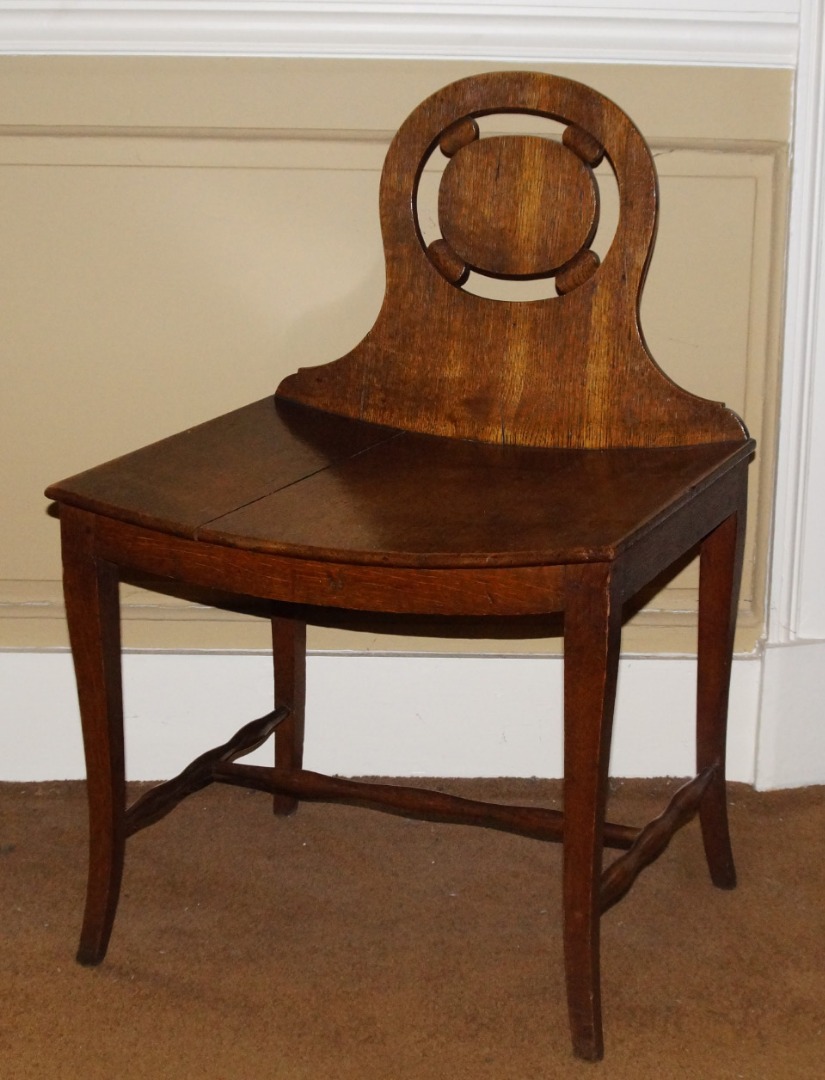 Appraisal: An unusual thC oak hall chair with a shaped pierced