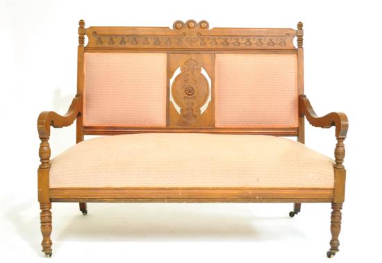 Appraisal: Eastlake settee pink upholstery shaped arms and ring turned legs