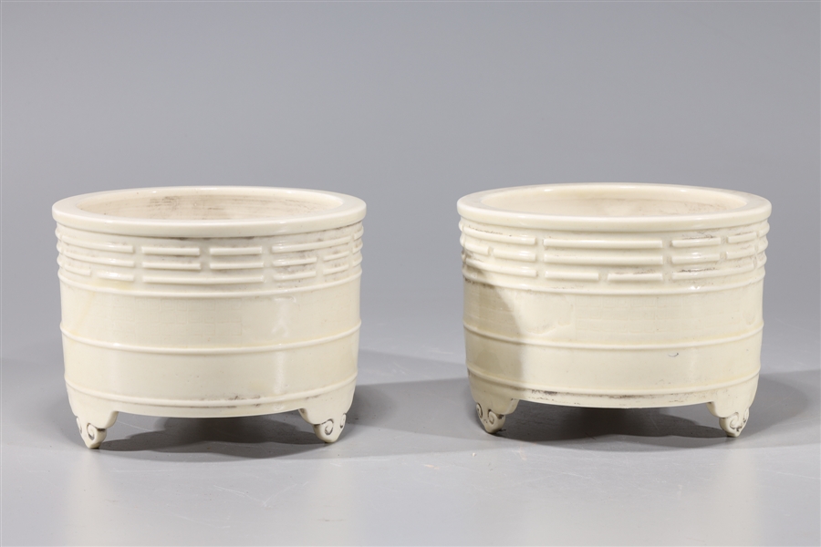 Appraisal: Two Chinese porcelain tripod censers with molded designs to body