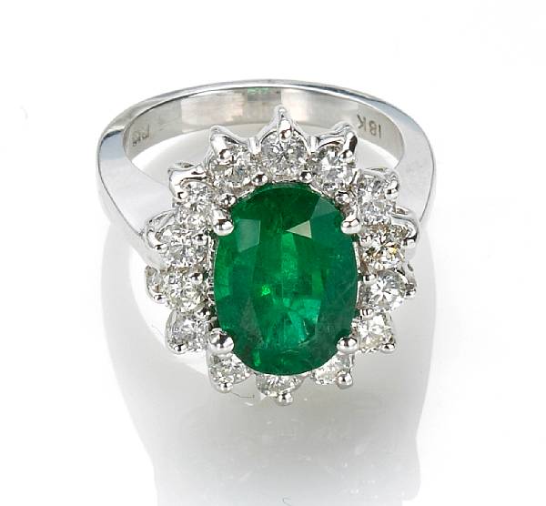 Appraisal: An emerald and diamond ring centering an oval-cut emerald weighing