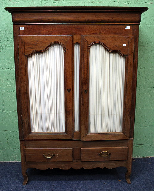 Appraisal: A FRENCH OAK ARMOIRE with shaped cupboard doors two frieze