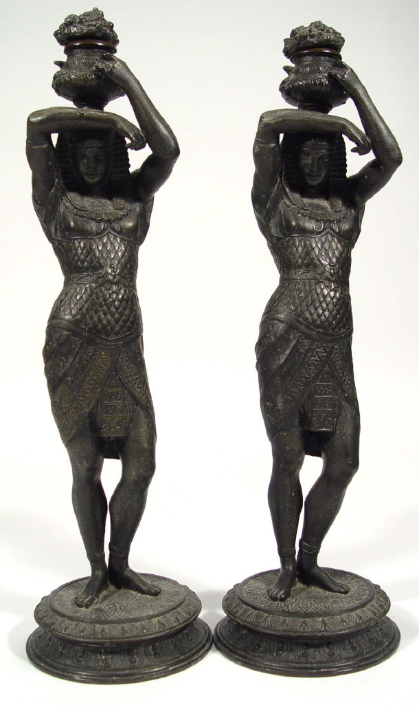 Appraisal: Two Egyptian style spelter candlesticks and covers modelled as figures